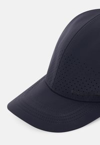 Gorra azul marino con diseño perforado, textura suave, visera curva y detalles cosidos. Logo impreso en la parte frontal.
