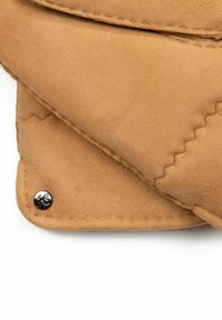 Tan suede pouch with a smooth texture, featuring rounded edges and a black metal snap detail. Visible stitching along the folds.