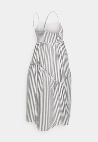 Vestido sem alças em branco e preto com riscas verticais, apresentando uma cintura ajustada, saia rodada e tecido texturizado com detalhes franzidos.