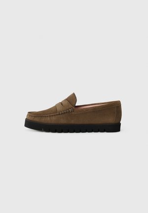 Brown suede loafers with a rounded toe, elastic band detail, and textured black rubber sole. Interior features soft pink lining.