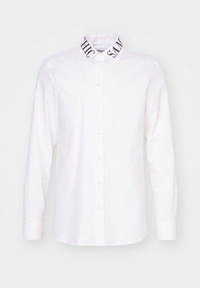 White shirt with a button-up front and long sleeves. Notable contrasting printed collar detailing with "CHIC" and "SAME." Plain fabric texture.
