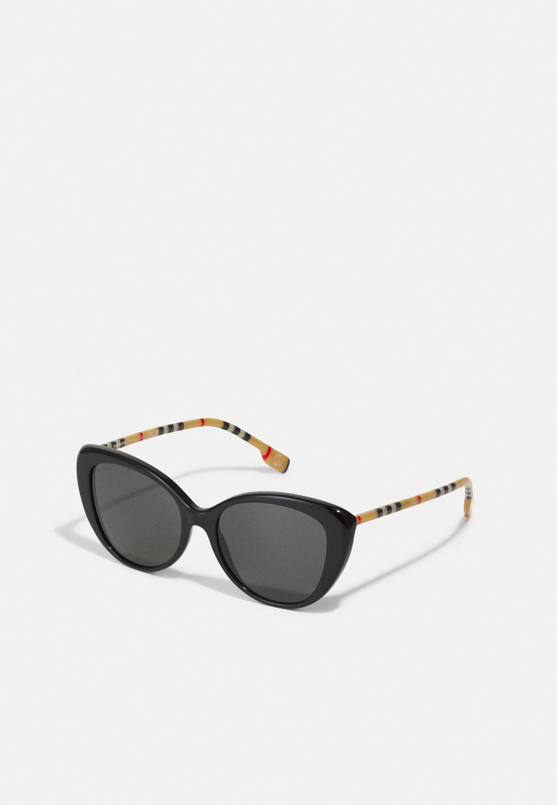 Black cat-eye sunglasses with dark lenses. Temple arms feature a multicolored striped pattern on a light background. Smooth plastic frame.