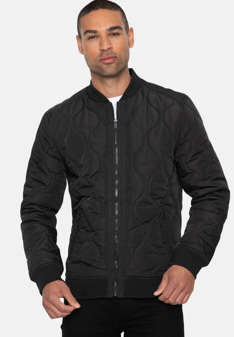 Zwarte quilted bomberjack met een ritssluiting aan de voorkant, ribgebreide manchetten en zoom. Voorzien van zijzakken en een gladde textuur.