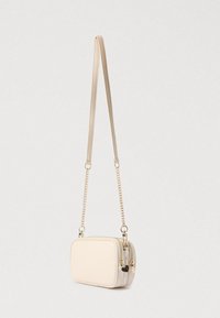 Bézs színű, téglalap alakú átvetős táska kettős cipzáras rekeszekkel, arany lánccal és bőrszíjjal, valamint szív alakú cipzárhúzókkal.