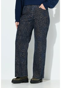 Dunkelblaue Leopardenmuster-Jeans mit geradem Schnitt. Das Denim-Material hat eine strukturierte Oberfläche und verfügt über vier Taschen. Kombiniert mit klobigen, schwarzen Plateaustiefeln.