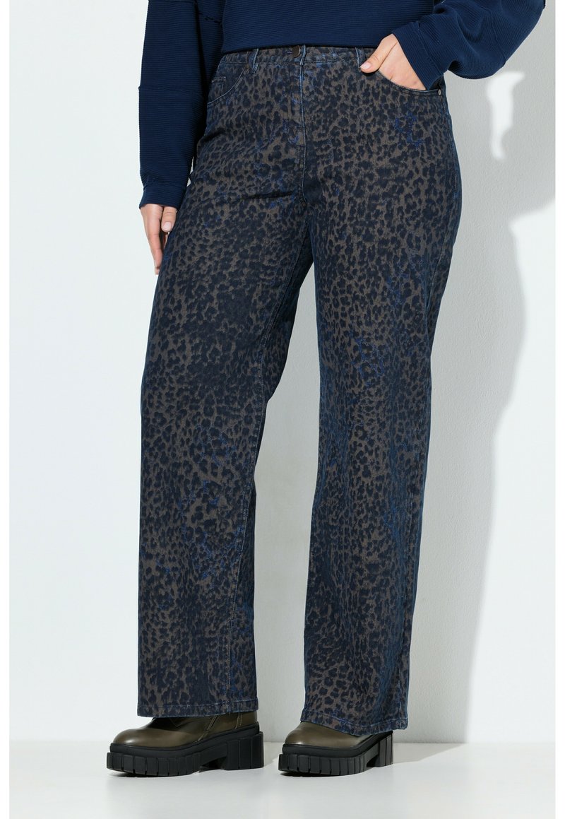 Dunkelblaue Leopardenmuster-Jeans mit geradem Schnitt. Das Denim-Material hat eine strukturierte Oberfläche und verfügt über vier Taschen. Kombiniert mit klobigen, schwarzen Plateaustiefeln.