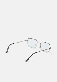 Ochelari metalici dreptunghiulari cu rame subțiri de argint, lentile clare și vârfuri de brațe din plastic negru; prezintă un design minimal.