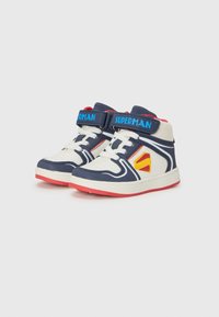 Baskets montantes présentant un design bleu marine et blanc, des semelles rouges et un logo "Superman" sur la sangle. Idéales pour le jeu actif des enfants.