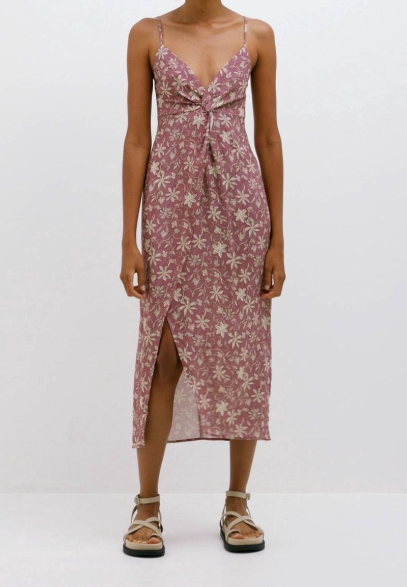 Midikleid mit floralem Muster in einem staubigen Rosaton, dünnen Spaghettiträgern, einem geknoteten Vorderteil und einem hohen Schlitz bis zum Oberschenkel für zusätzliche Details.