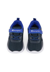 Zapatillas deportivas de color gris oscuro con detalles azules. Parte superior de malla, suela de goma, cordones elásticos y correa ajustable con logo. Diseño de puntera redondeada.
