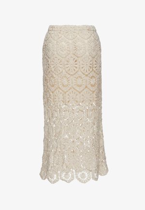 Jupe en dentelle crochet couleur crème avec motifs floraux circulaires et ourlet festonné, longueur midi et taille ajustée.