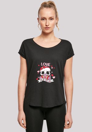 Black T-shirt with rolled sleeves featuring a graphic of a skull, pink hearts, and the text "LOVE IS IN THE AIR" on the front.