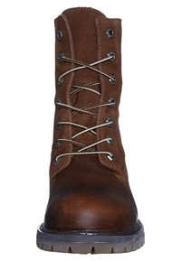 Bota marrón de cuero con cordones, parte superior de ante, herrajes plateados y suela de goma texturizada. Presenta un diseño robusto y costuras visibles.