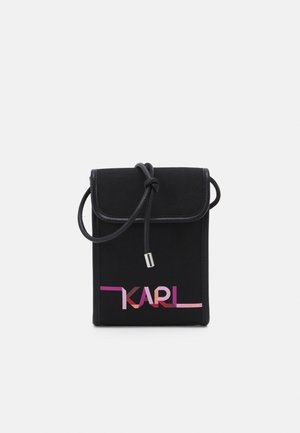 Sac bandoulière rectangulaire noir avec sangle cordon réglable, fermeture à rabat et logo "KARL" en dégradé rose sur le devant.