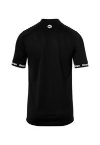 Zwarte sportshirt met korte mouwen en een ronde hals; beschikt over een wit "K" logo op de achterkant en "Kempa" branding op de mouwen. Gladde stoftextuur.