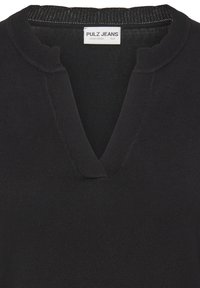 Czarna bluza z dekoltem w kształcie litery V, z prążkowaną fakturą i falistymi krawędziami przy dekolcie. Metka z napisem "PULZ JEANS".