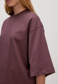 Overmaatse paarse katoenen t-shirt met een ronde hals en korte mouwen, met een gladde textuur en een minimalistisch ontwerp.