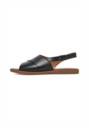 Sandalias slingback de cuero negro con punta redonda, diseño cruzado y suela plana color marrón claro. Incluyen correa ajustable en el tobillo.