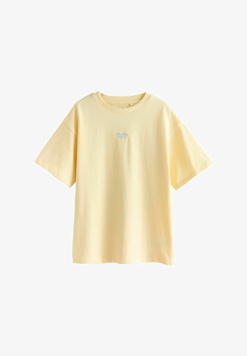 Kurzärmliges, locker sitzendes T-Shirt aus hellgelber Baumwolle mit kleinem blauem "studio aura" Logo auf der Brust. Glatte Textur.