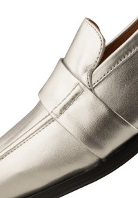 Medenkové strieborné loafers s hladkým vzhľadom, s mokasínovým štýlom vrchnej časti a elegantným dizajnom, zvýraznené šitými detailmi a plochou podrážkou.