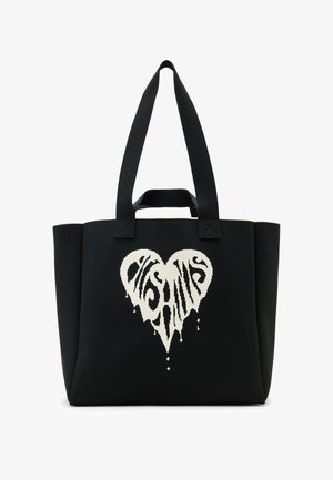 Zwarte draagtas gemaakt van duurzaam stof, met een wit druppelend hartontwerp en gedraaide tekst in het midden. Dubbele stoffen hengsels om te dragen.