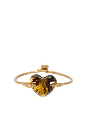 Złota bransoletka z teksturowanym, bursztynowym sercem w kształcie serca przewleczonym przez opaskę, na białym tle.