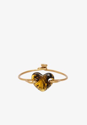 Złota bransoletka z teksturowanym, bursztynowym sercem w kształcie serca przewleczonym przez opaskę, na białym tle.