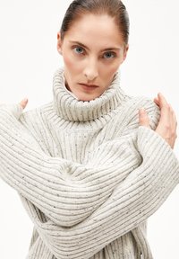 Fleckiger, dicker Strickrollkragenpullover in Hellgrau mit geripptem Muster, oversized Ärmeln und lockerer Passform.