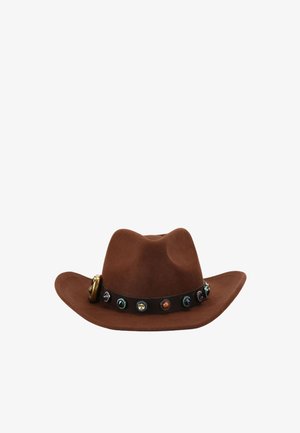 Chapeau de cowboy marron avec un bandeau en cuir foncé décoré de conchos ronds colorés et une petite boucle en laiton sur un côté.