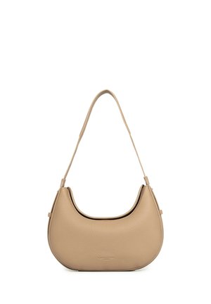 Sac à épaule en cuir beige texturé avec une forme courbée et une bandoulière unique suspendu sur un fond blanc.