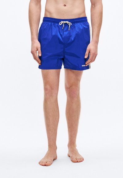 Shorts de bain bleus en tissu léger, avec une taille à cordon, des rayures latérales et un petit logo sur la partie inférieure de la jambe.