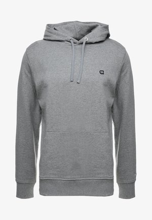 Felpa grigia con cappuccio, tasca kangaroo frontale, cappuccio con cordino, polsini e fondo a costine, e piccolo logo "CK" sul lato sinistro del petto.