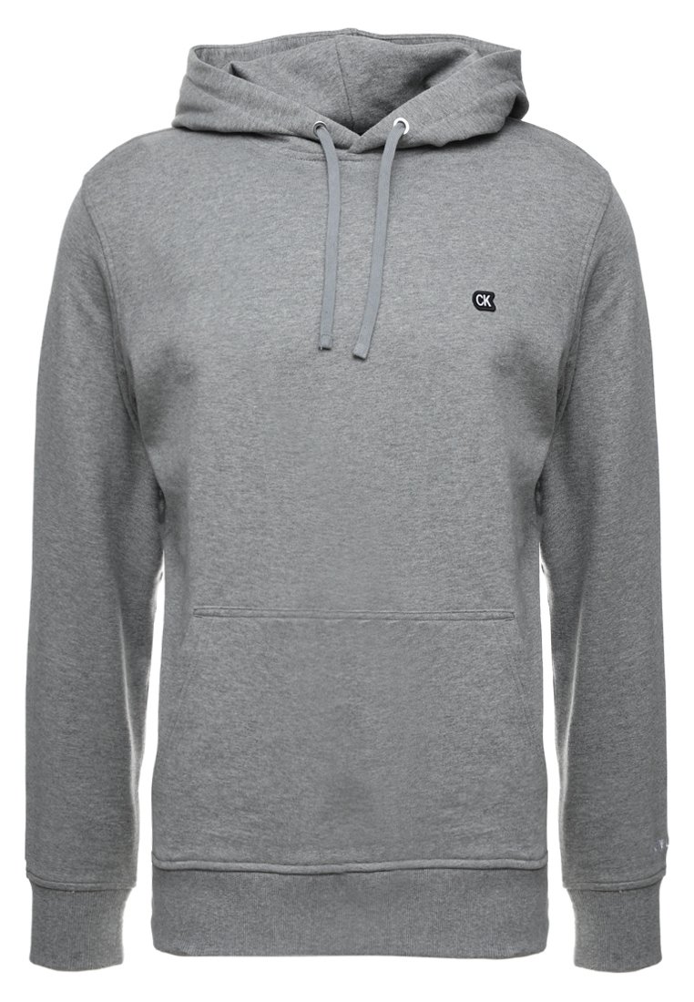 Šedá mikina s kapucí, přední klokaní kapsou, šňůrkovou kapucí, žebrovanými manžetami a lemem, a malým logem "CK" na levé hrudi.