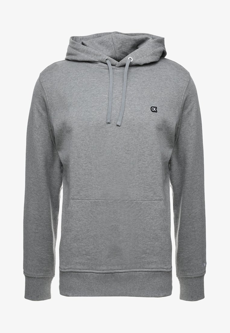 Šedá mikina s kapucí, přední klokaní kapsou, šňůrkovou kapucí, žebrovanými manžetami a lemem, a malým logem "CK" na levé hrudi.
