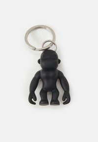 Black rubber keychain featuring a stylized, cartoonish figure with a round head, muscular arms, and a sturdy metal ring for attachment.