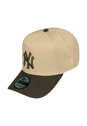 Beige fabric cap with dark brown visor, featuring an embroidered logo. Adjustable back and curved brim. Smooth texture throughout.