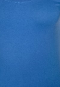 Modrý přiléhavý top bez rukávů s hladkou, elastickou texturou. Má kulatý výstřih a bezešvý design, vhodný pro vrstvení nebo běžné nošení.