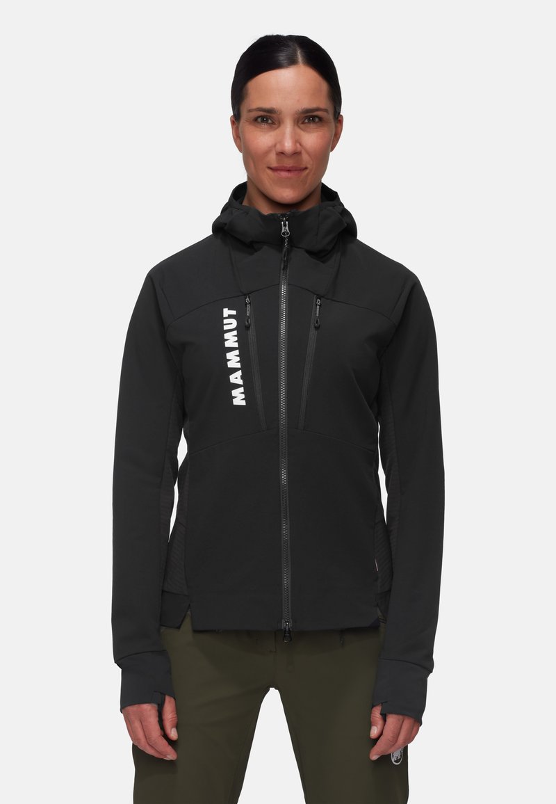 Schwarze Softshell-Jacke mit hohem Kragen, Reißverschlusstaschen und einem auffälligen weißen Logo. Sie hat eine sportliche Passform und Daumenlöcher.