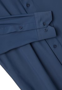 Camisa azul marino de botones, hecha de tela suave. Presenta un cuello estándar, cierre de botones y mangas largas con puños.