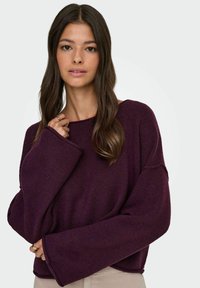 Suéter morado de gran tamaño con mangas anchas, hecho de un material texturizado suave. Presenta un escote barco y un corte relajado para mayor comodidad.