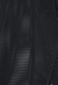 Tessuto in rete nera con un motivo di perforazione a diamante, caratterizzato da una texture liscia e una caduta flessibile, adatto per diverse applicazioni.