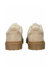 Zapatos de ante beige con forro de piel sintética color crema, que presentan una suela de goma gruesa. La parte trasera de cada zapato muestra el logo "BLACKSTONE" en relieve.