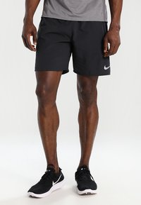 Schwarze Sportshorts aus leichtem, atmungs活material. Verfügt über einen elastischen Bund und ein kleines reflektierendes Logo an der Seite.