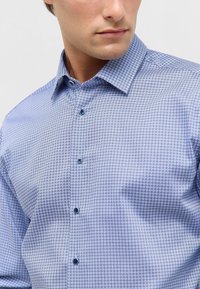 Lichtblauw gestreept shirt met een klein geometrisch patroon, knoopsluiting aan de voorkant en contrasterende blauwe knopen, met een gestructureerde kraag.