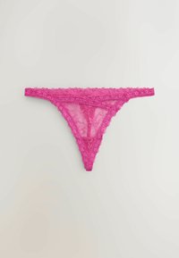 String en dentelle rose à motifs floraux, étalé à plat sur un fond gris clair.
