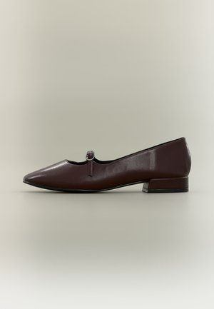 Zapato plano de cuero marrón oscuro con tacón cuadrado bajo y una pequeña correa redonda con hebilla en la parte superior.