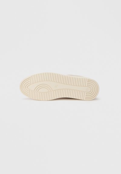 Μπεζ λαστιχένια σόλα αθλητικού παπουτσιού με διακοσμητικό πέλμα, που διαθέτει έντονες αυλακώσεις και ομαλό τόξο σχεδίασης. Καθαρό, μινιμαλιστικό στυλ.