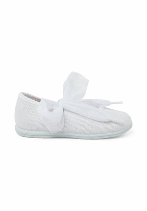 Zapato textil blanco con una superficie texturizada, forma redondeada y un lazo de cinta transparente suave y sobredimensionado en la parte delantera, que presenta una suela de color azul claro.