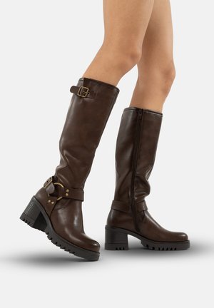Brown leather knee-high boots with a chunky heel, decorative buckle accents, and side zipper. Textured sole for grip.