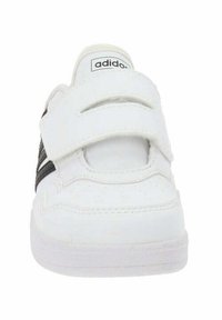 Sneaker Adidas bianche con una parte superiore in pelle liscia, due cinturini in Velcro e una suola in gomma bianca testurizzata. Presenta un accento nero di lato.